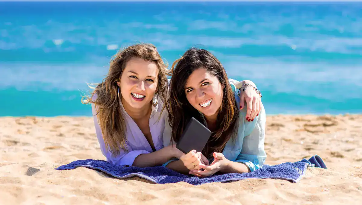 Two girls relaxing for beach towel at beach | Best Beach Towels For Travel Lovers