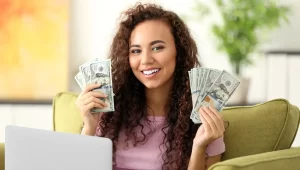 Girl carrying dollars in both hands, how to make money while travelling