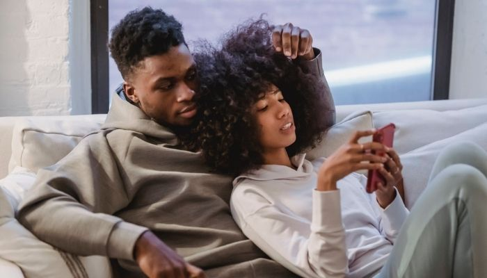 Couple sitting together and using mobile